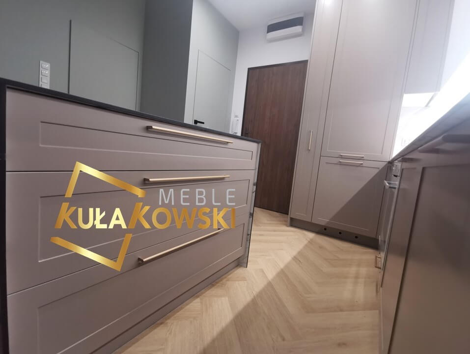 Wyspa z długimi złotymi uchwytami we frontach kuchennych